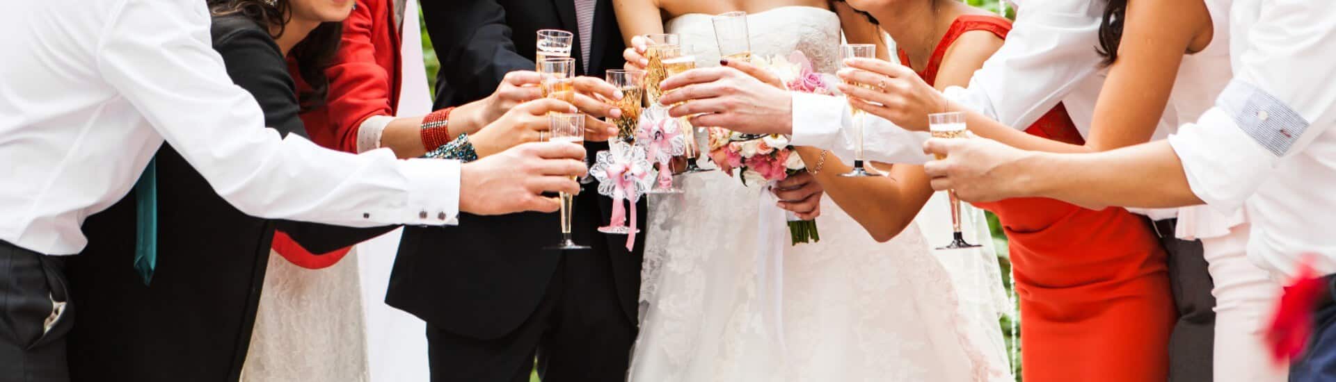 A bride and groom with friends toasting with champagne flutes